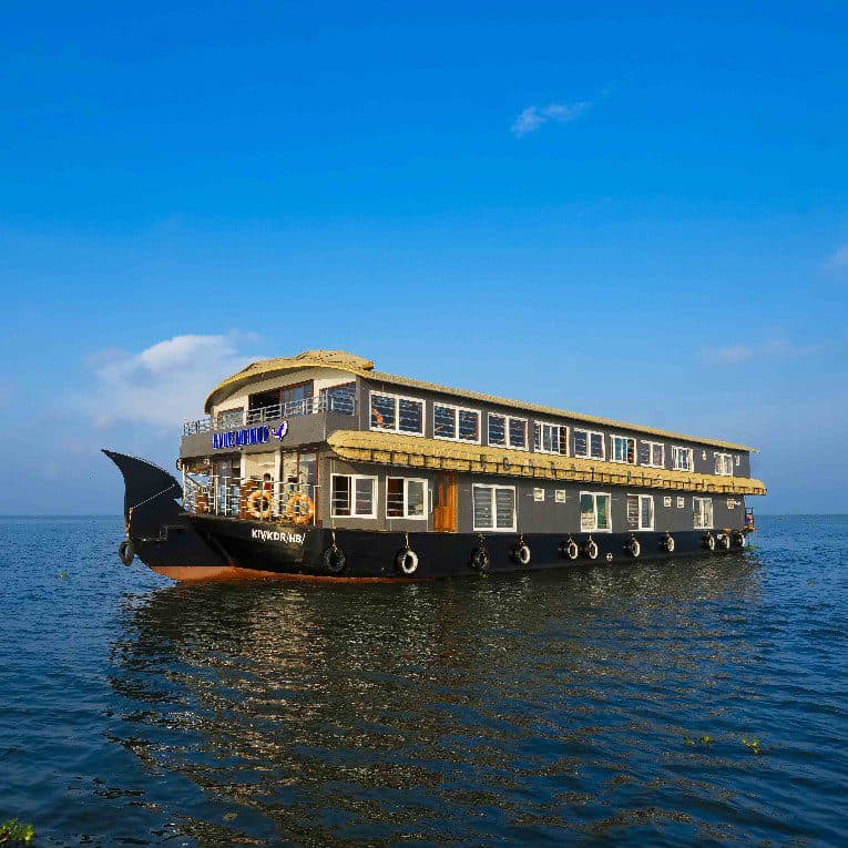 Houseboat cruising through Kerala's scenic backwaters with stunning views and modern amenities.